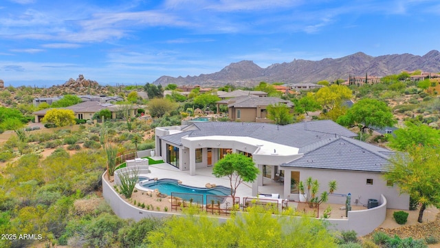 rear view of house featuring a residential view, stucco siding, a mountain view, a fenced backyard, and a garage