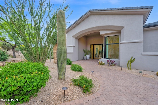 view of exterior entry with stucco siding