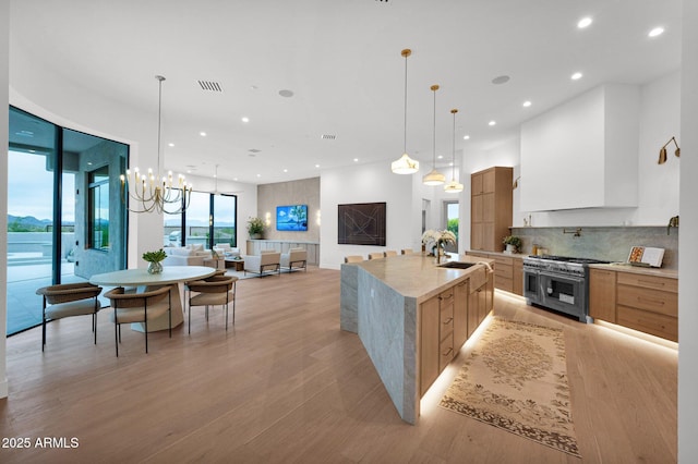 kitchen featuring a sink, range with two ovens, recessed lighting, and modern cabinets