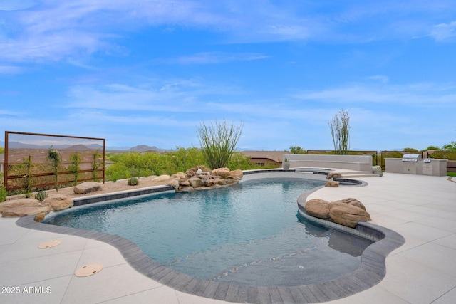 view of pool with a patio, fence, exterior kitchen, a mountain view, and a fenced in pool
