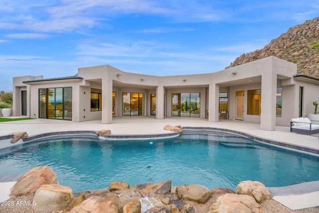 outdoor pool with a patio area and a mountain view