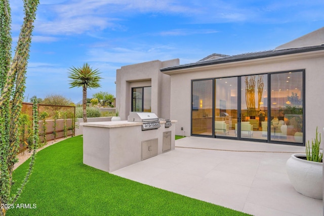 rear view of house featuring stucco siding, area for grilling, a patio area, a fenced backyard, and a lawn