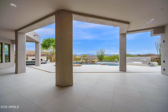 view of patio / terrace featuring an outdoor pool, an in ground hot tub, and a mountain view