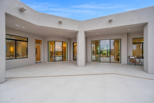 back of property with a patio area and stucco siding