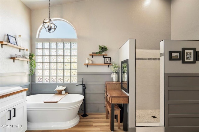 bathroom featuring a freestanding bath, plenty of natural light, wood finished floors, and vanity