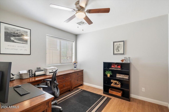 office featuring light wood finished floors, ceiling fan, visible vents, and baseboards