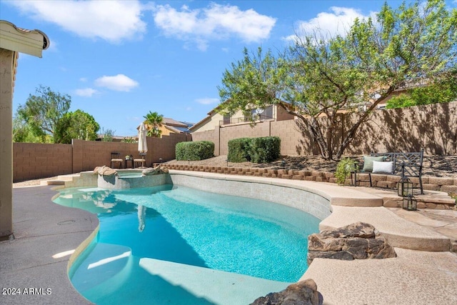 view of pool featuring a pool with connected hot tub and a fenced backyard