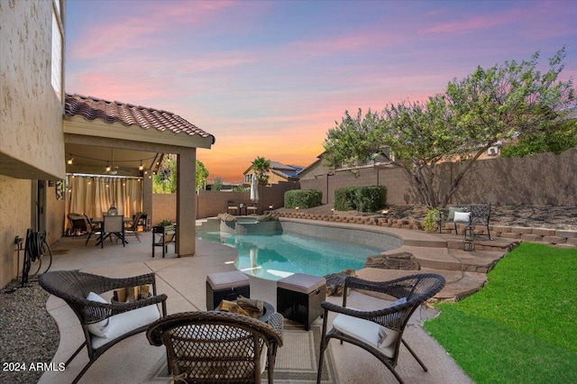 pool at dusk featuring a patio