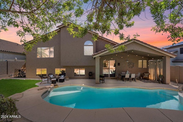 pool at dusk featuring a patio