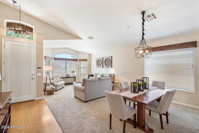 dining area featuring lofted ceiling, visible vents, a chandelier, and light wood-style flooring