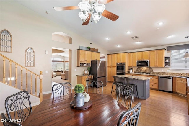 dining space featuring vaulted ceiling, ceiling fan, and light hardwood / wood-style flooring