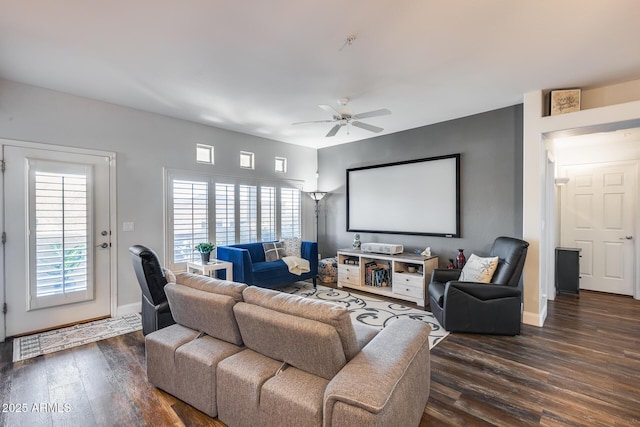 home theater room featuring dark wood-type flooring and ceiling fan