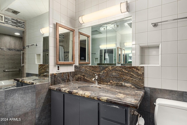 bathroom featuring vanity, tile walls, and toilet