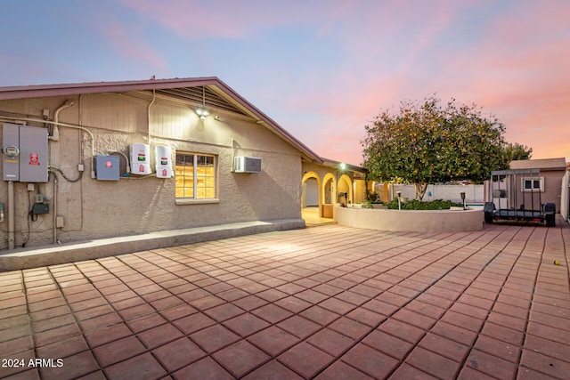 patio terrace at dusk with a wall mounted air conditioner