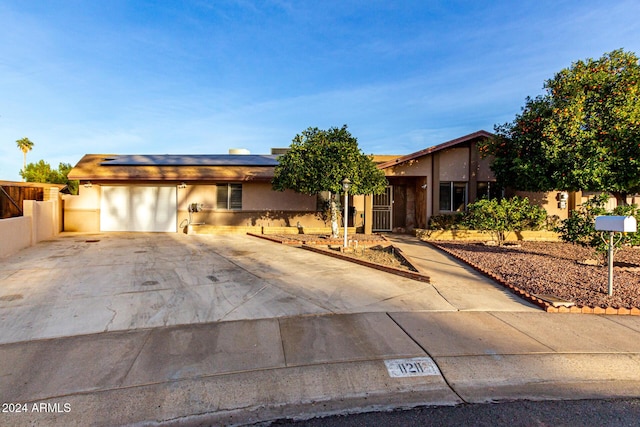 view of front of home featuring solar panels and a garage