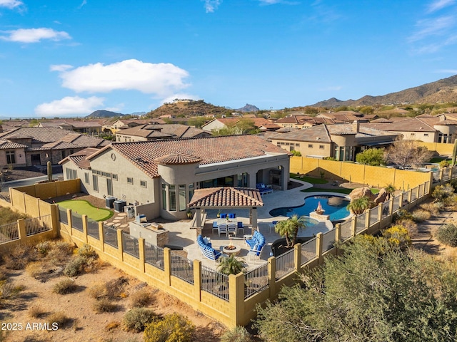 rear view of house with a patio area, a mountain view, a fenced backyard, and a residential view