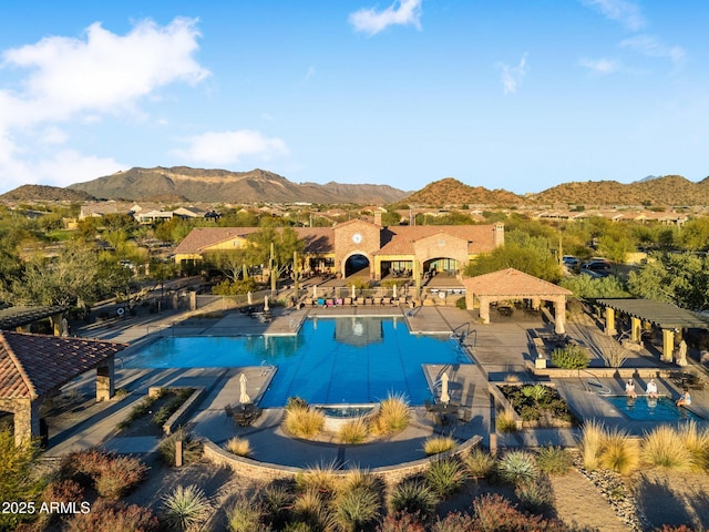 community pool with a gazebo, a mountain view, and a patio