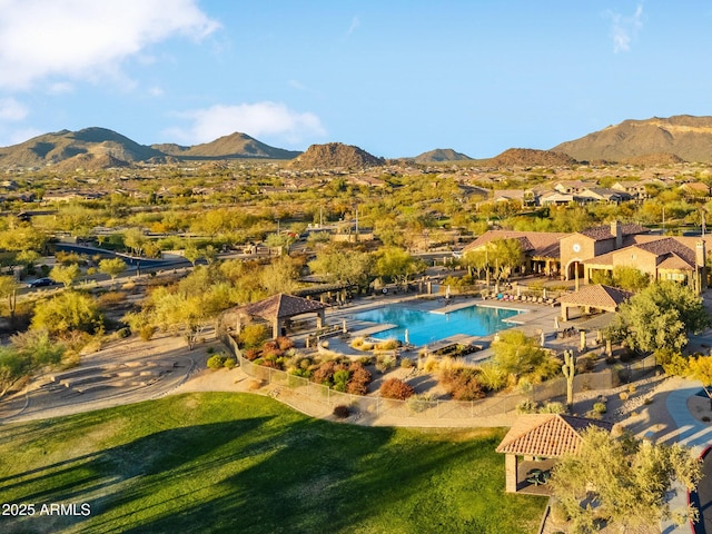 view of swimming pool featuring a lawn and a mountain view