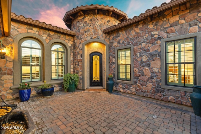 entrance to property featuring a tile roof