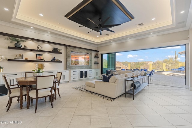 living area featuring visible vents, a tray ceiling, light tile patterned flooring, recessed lighting, and ceiling fan