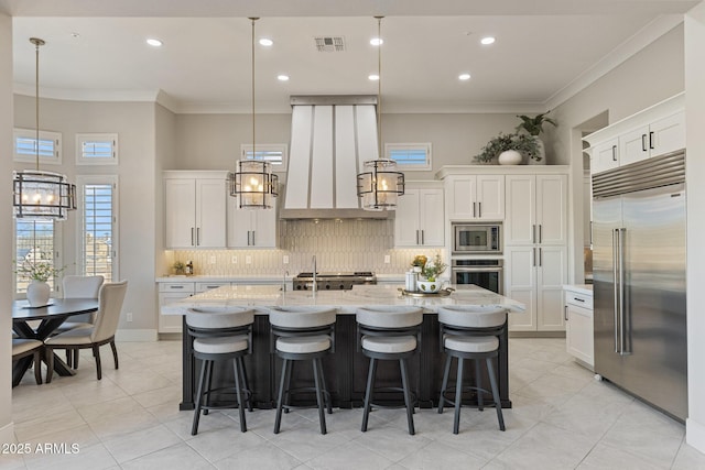 kitchen with crown molding, visible vents, built in appliances, and a chandelier