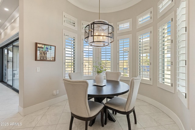 dining room with light tile patterned floors, baseboards, and a chandelier