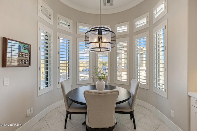 dining room featuring a wealth of natural light, light tile patterned floors, baseboards, and a notable chandelier