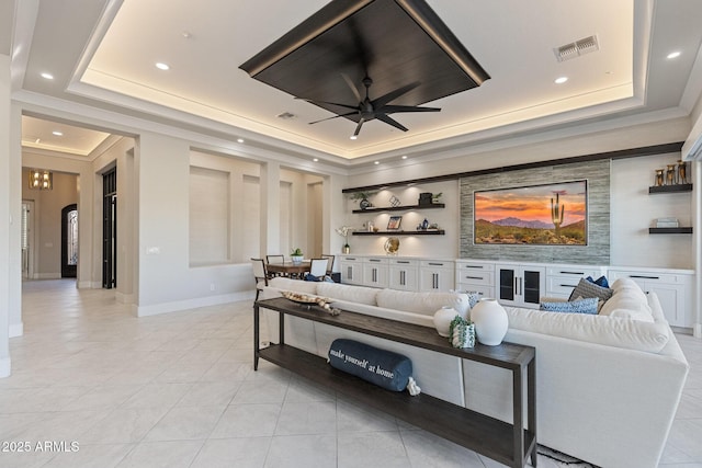 living room with light tile patterned floors, a tray ceiling, and visible vents