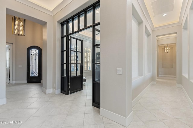 entryway featuring light tile patterned floors, visible vents, baseboards, and an inviting chandelier