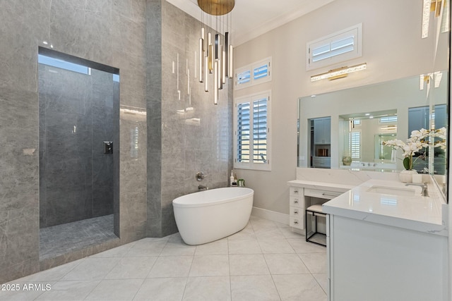 full bathroom featuring tile patterned flooring, crown molding, walk in shower, a soaking tub, and vanity