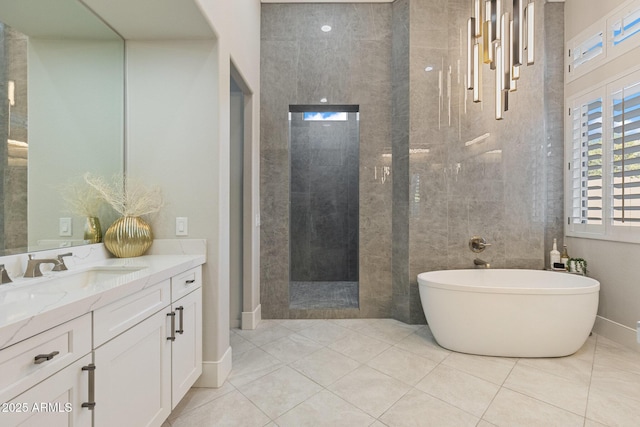 full bath with tile patterned flooring, a freestanding bath, vanity, and walk in shower