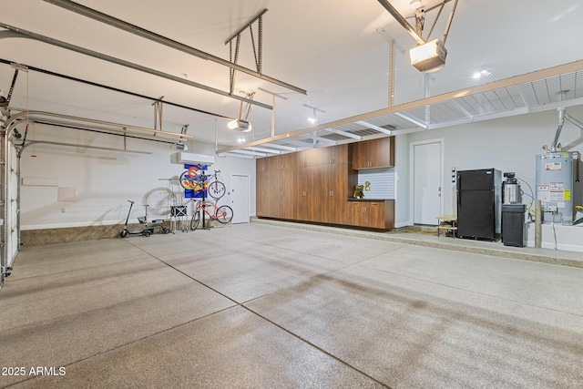 garage featuring a garage door opener, water heater, and freestanding refrigerator