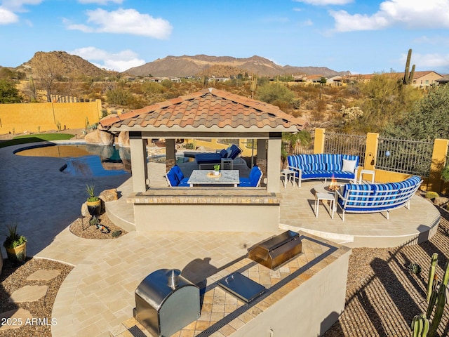 view of pool with a gazebo, fence, a mountain view, and a patio