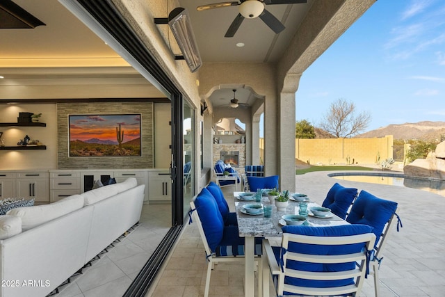 view of patio / terrace featuring a fenced in pool, ceiling fan, outdoor dining area, a fenced backyard, and a mountain view