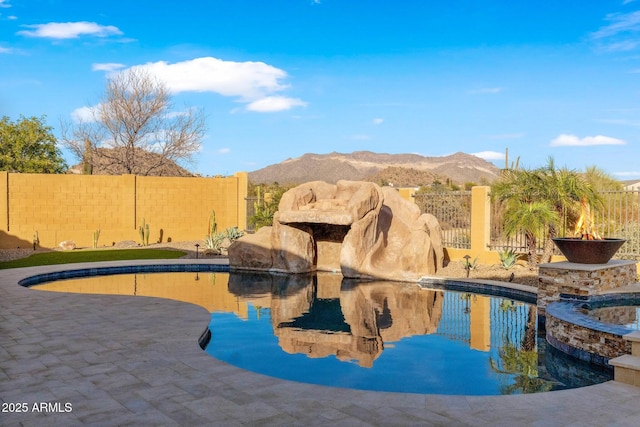 view of swimming pool featuring a mountain view, a patio, and a fenced backyard