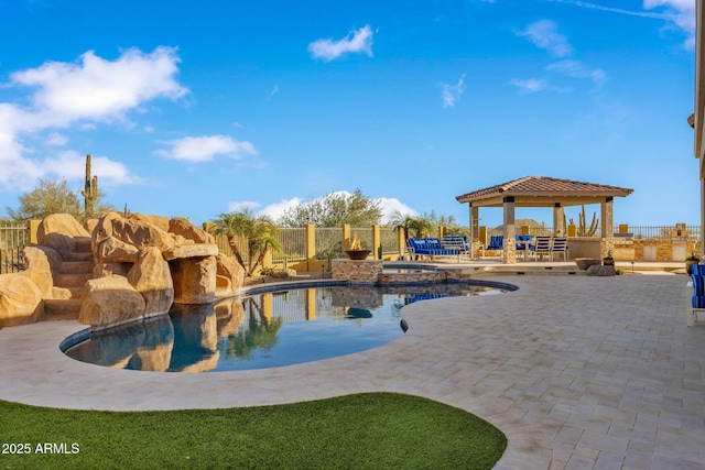 view of pool with a gazebo, fence, a pool with connected hot tub, and a patio