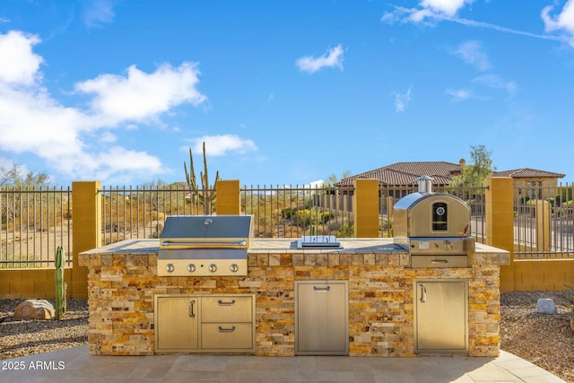 view of patio / terrace featuring an outdoor kitchen, a grill, and fence