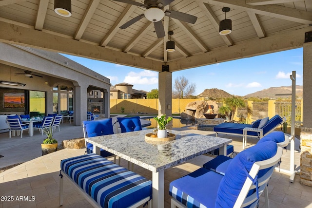 view of patio featuring a gazebo, outdoor lounge area, outdoor dining area, a fenced backyard, and a mountain view