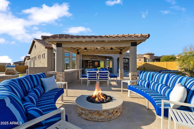 view of patio / terrace with an outdoor living space with a fire pit and fence