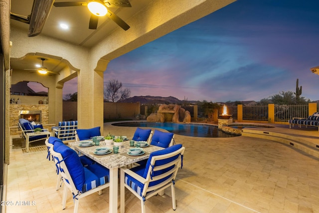 view of pool with a patio area, an in ground hot tub, an outdoor stone fireplace, and a fenced backyard