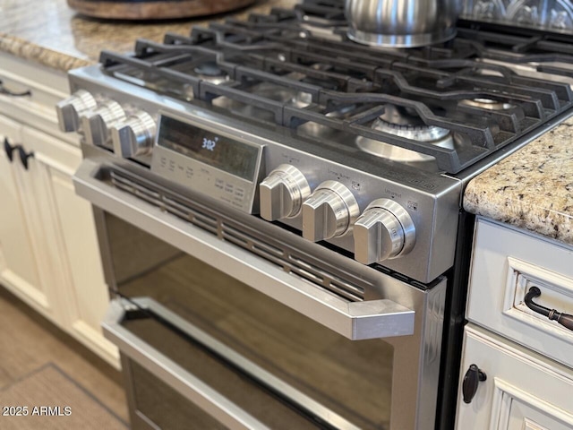 room details featuring gas range and light stone countertops