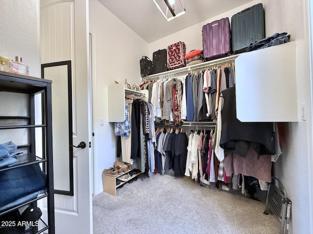 spacious closet with lofted ceiling and light colored carpet