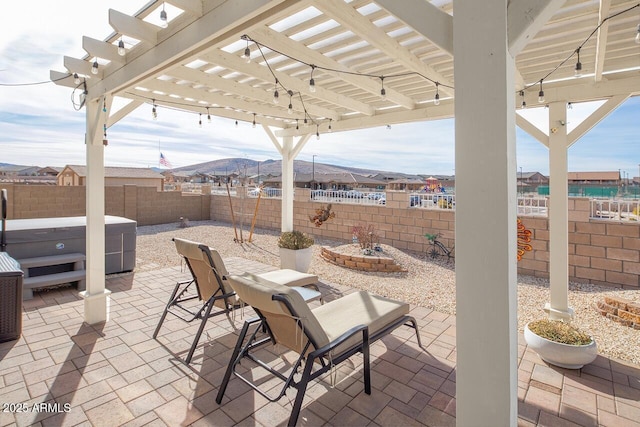 view of patio featuring a mountain view and a hot tub