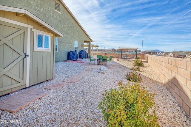 view of yard with a storage shed and a patio area