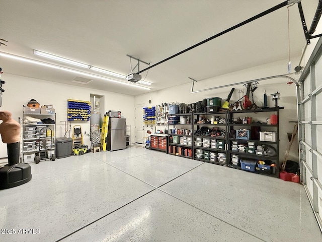 garage with stainless steel refrigerator and a garage door opener