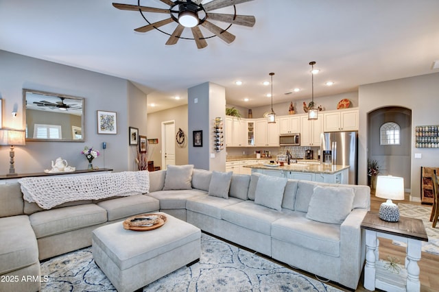 living room with ceiling fan, sink, and light hardwood / wood-style floors