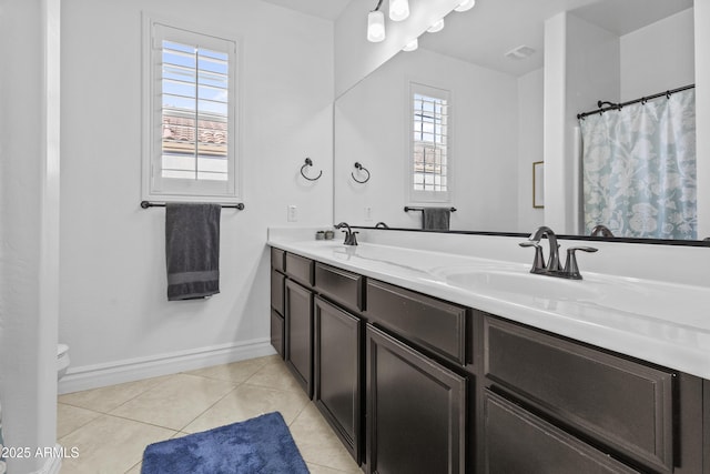 full bath featuring a wealth of natural light, tile patterned flooring, baseboards, and a sink