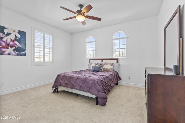 bedroom featuring light colored carpet, baseboards, and ceiling fan