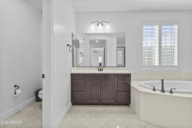 bathroom with baseboards, toilet, a bath, tile patterned floors, and vanity