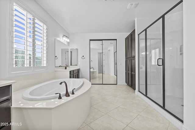 bathroom with tile patterned floors, a shower stall, vanity, and a garden tub